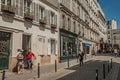 Couple leaving home with stroller in busy alley of Montmartre at Paris.